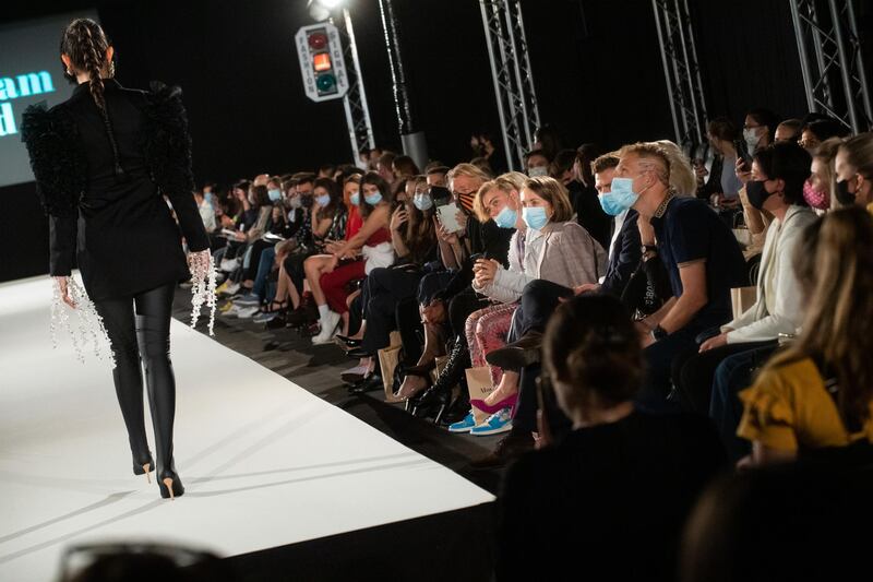 Spectators watch a model walking the runway at the Moulham Obid show during the MQ Vienna Fashion Week.20 at Museumsquartier in Vienna, Austria. Getty Images