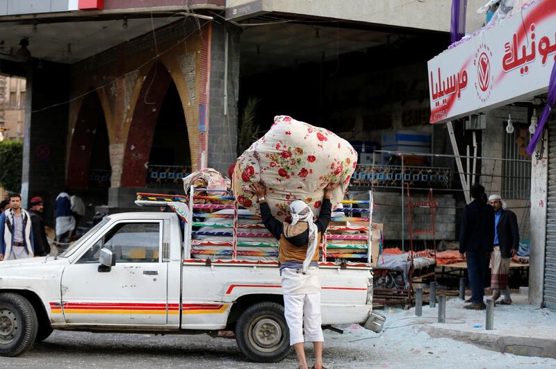 A worker collects belongings from his store which was smashed up during  clashes between Saleh's forces and Houthis,in Sanaa. Khaled Abdullah / Reuters