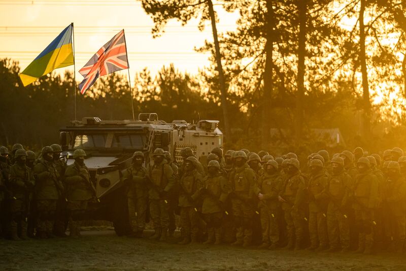 Ukrainian and British flags fly as Ukrainian volunteer recruits take part in prayers in south-east England. Getty Images