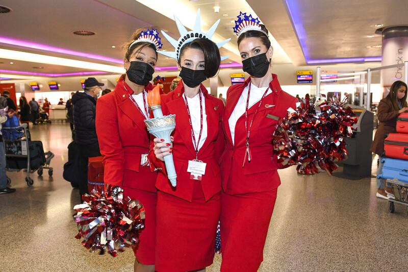 Virgin Atlantic cabin crew members pose at London Heathrow Airport’s Terminal 3 before the departure of Virgin Atlantic flight VS3