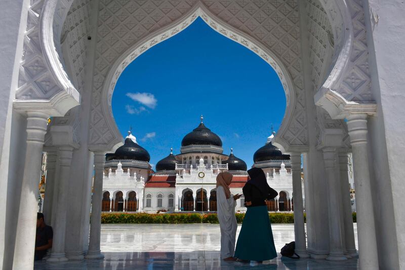Muslim women stand outside Baiturrahman grand mosque in Banda Aceh.   AFP