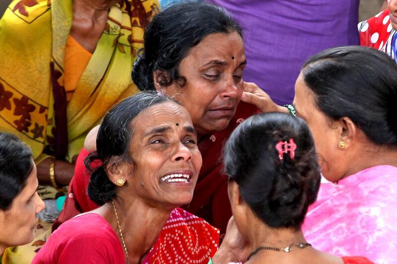 People hold vigil on Saturday at the site of a building that collapsed in Mumbai. Rajanish Kakade / AP Photo
