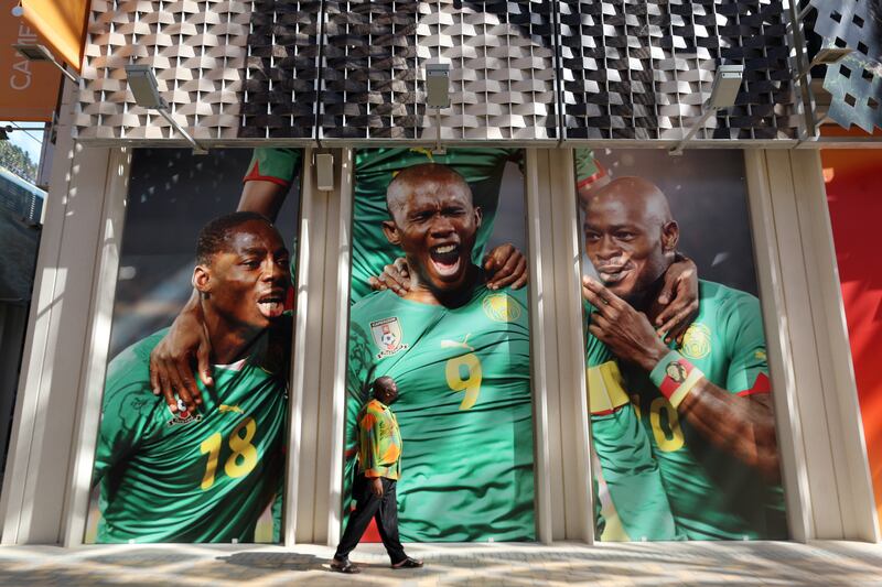 A visitor looks at a massive photo of Samuel Eto'o outside the Cameroon pavilion.