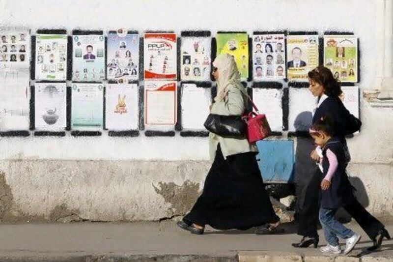 Tunisians walk past elections posters in Tunis Wednesday, Wednesday, Oct. 19, 2011 ahead of the landmark Oct. 23 election for a constitutional body that will determine the future of this North African nation which overthrew its longtime dictator in January. (AP Photo/Francois Mori) *** Local Caption *** Tunisia Elections.JPEG-06b73.jpg