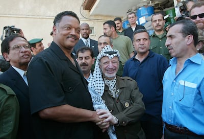 Palestinian leader Yasser Arafat clasps hands with Rev Jesse Jackson in Ramallah. Getty