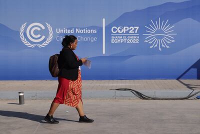 A woman walks past a sign on day one of Cop27 in Sharm El Sheikh, Egypt, last November. Getty Images