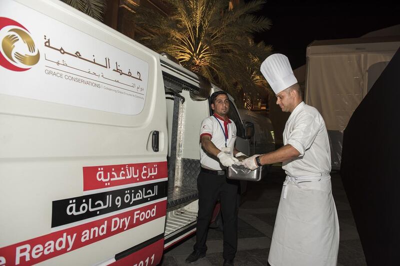 Emirates Palace executive sous chef Carmine Pecoraro gives leftover iftar food to Saving Grace, an arm of Emirates Red Crescent, to be distributed to poor people. Vidhyaa for The National