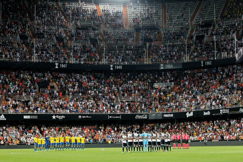 epa06150568 Valencia CF (R) and UD Las Palmas (L) players observe a minute's silence to pay tribute to victims of the terrorist attacks in Barcelona and Cambrils, before the Spanish Liga Primera Division soccer match played at Mestalla stadium, in Valencia, eastern Spain, 18 August 2017.  EPA/MANUEL BRUQUE