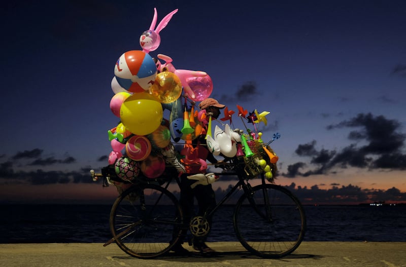A balloon seller pushes his bicycle while looking for customers in Colombo, Sri Lanka. Reuters
