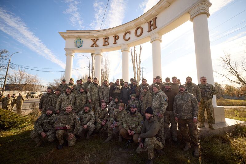 Ukrainian troops line up with President Volodymyr Zelenskyy, who is standing below the centre column, in Kherson. The city has been retaken from Russia. Reuters