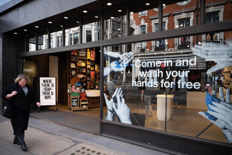 LONDON, ENGLAND - MARCH 17: A woman walks past a cosmetic store that is offering a free hand-washing facility on March 17, 2020 in London, England. Boris Johnson held the first of his public daily briefing on the Coronavirus outbreak yesterday and told the public to avoid theatres, going to the pub and work from home where possible. The number of people infected with COVID-19 in the UK reached 1500 today with 36 deaths. (Photo by Leon Neal/Getty Images)