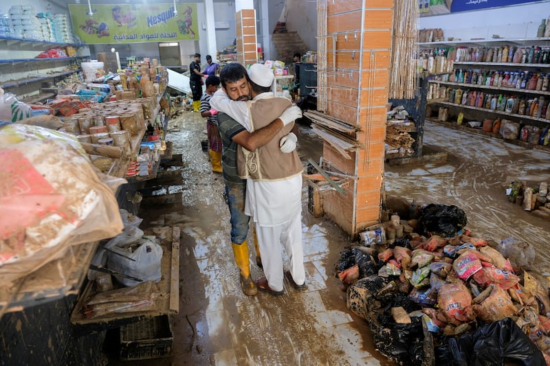 Two men embrace inside a grocery shop damaged by fatal flooding in Derna, Libya. Reuters