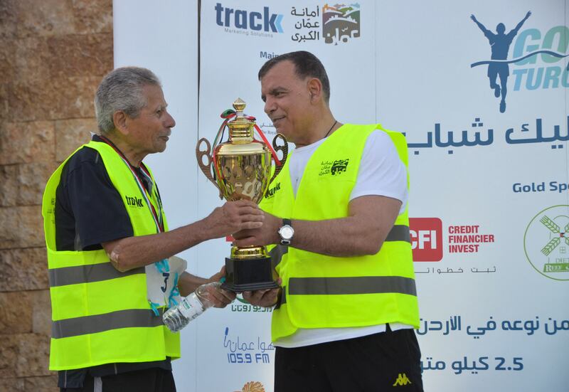 Jordanian Samer Jaber receives a trophy after winning a walking race for the over-60s in King Hussein Park in Amman. All photos by Reuters