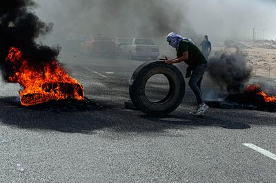 A protester burns tyres during a rally in Basra in June. AP

