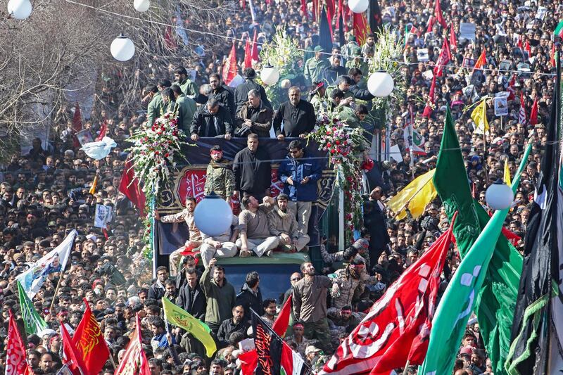 Iranian mourners gather around a vehicle carrying the coffin of Qassem Suleimani during the final stage of funeral processions, in his hometown Kerman.  AFP