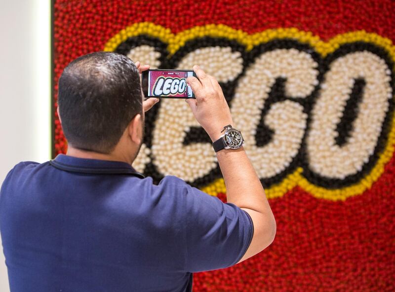 DUBAI, UNITED ARAB EMIRATES - Visitors taking photos of the Lego logo at the reception at the opening of the new Lego office in Dubai Design District.  Leslie Pableo for The National