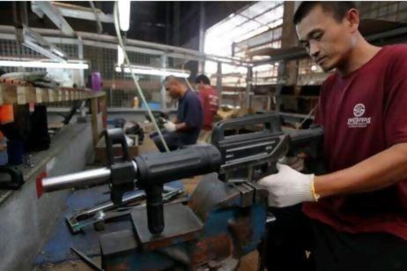 A formerly illegal gunsmith inspects a newly assembled multi-action shotgun at Shooters Arms, a gun manufacturing company in Cebu in the central Philippines.
