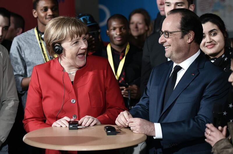French President Francois Hollande and German Chancellor Angela Merkel smile as they participate in the conclusion of exchanges of the “Café du Monde” organised by the Franco-German Youth Office in Metz, eastern France, as part of a Franco-German cabinet meeting. Frederick Florin / AFP