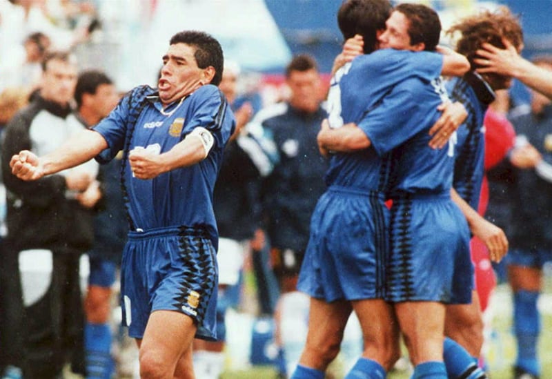 Argentine national soccer team captain, Diego Maradona (L) yells out as he and his teammates (R) celebrate after Argentina scored its second goal against Greece 21 June 1994 at Foxboro Stadium in Foxboro, Massachussetts. Argentian won the game 4-0. (Photo by DANIEL GARCIA / AFP FILES / AFP)