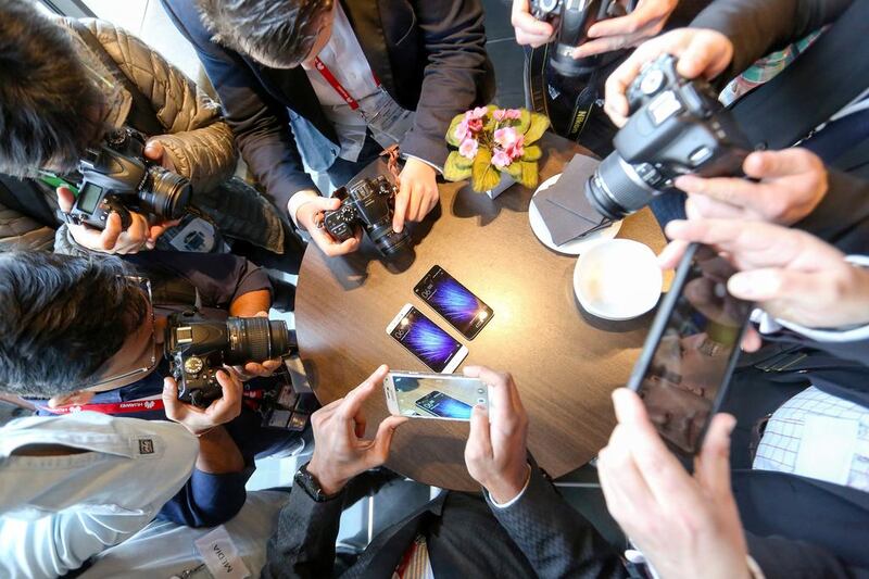 Attendees take photographs of the Mi5 smartphone, manufactured by Xiaomi, during its launch at the Mobile World Congress in Barcelona. Chris Ratcliffe / Bloomberg