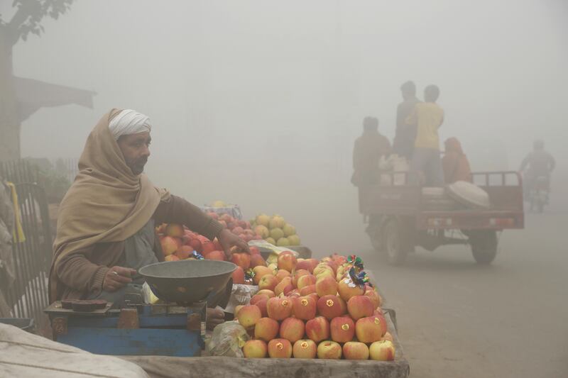 A vendor sells fruits on a foggy day in Lahore. KM Chaudary / AP Photo
