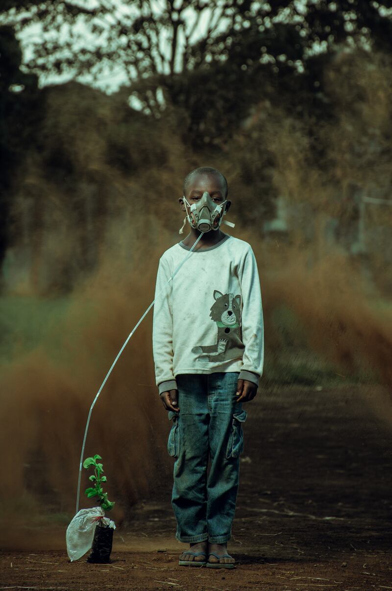 Winner of the Climate Action Award is 'The Last Breath', by Kevin Ochieng Onyango, depicting a boy taking in air from a plant, with a sandstorm brewing in the background in Kenya. Photo: Ochieng Onyango / Environmental Photographer of the Year 2021