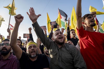Supporters salute during the broadcast of Hassan Nasrallah's speech in the Dahieh district of Beirut, on Friday. Bloomberg