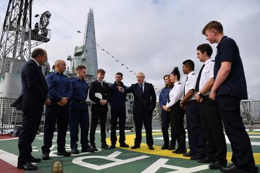 Britain's Prime Minister Boris Johnson (C) has announced he is awarding a £1.3bn contract to build five new warships to a UK firm during London International Shipping Week in London. AFP 