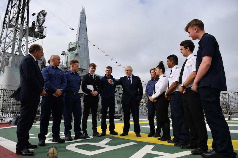 Britain's Prime Minister Boris Johnson (C) speaks to apprentices accompanied by Britain's Defence Secretary Ben Wallace (L) as he visits the NLV Pharos, a lighthouse tender moored on the river Thames to mark London International Shipping Week in London on September 12, 2019. / AFP / POOL / DANIEL LEAL-OLIVAS
