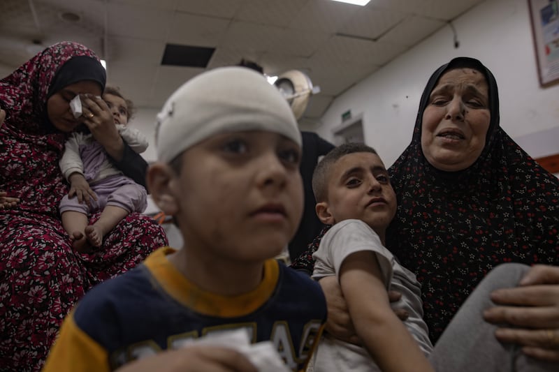 Children and women wait to receive treatment at Al Najjar Hospital following an Israeli air strike that hit their home in Rafah. EPA