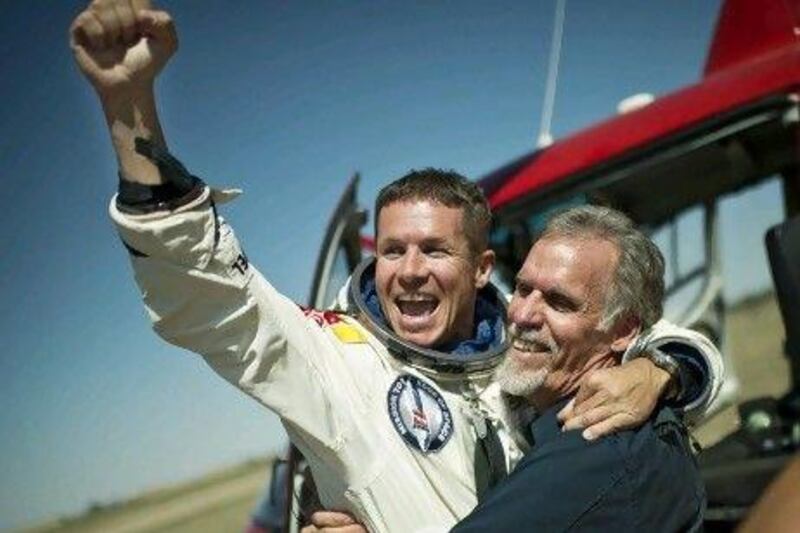 Austria's 'Fearless Felix' Baumgartner and technical project director Art Thompson celebrate after Baumgartner safely lands after jumping from his capsule about 39 kilometres from Earth.