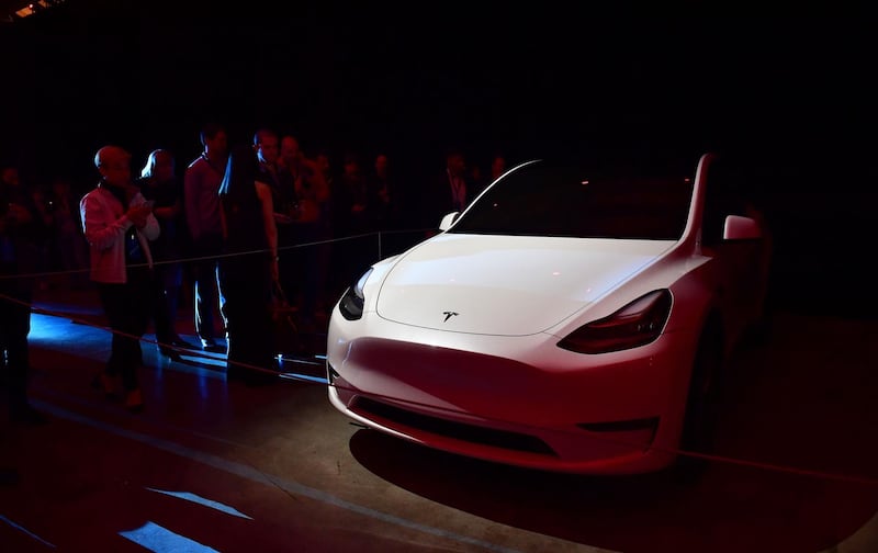 People view a model of the new Tesla Model Y. AFP