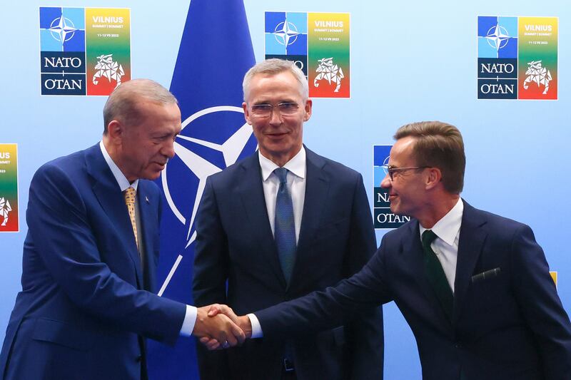 Turkey's President Recep Tayyip Erdogan, left, shakes hands with Sweden's Prime Minister Ulf Kristersson as Nato Secretary General Jens Stoltenberg looks on in Vilnius, Lithuania. AP