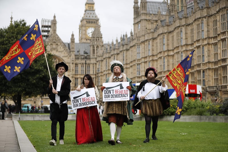 Protesters dressed in Tudor costume including one dressed as King Henry VIII hold signs protesting elements of the European Union Withdrawl Bill that is being debated by lawmakers in the House of Commons in London on September 7, 2017.
British lawmakers began debating Thursday a landmark bill to end Britain's membership of the European Union, with Prime Minister Theresa May gearing up for a major battle. The bill provides for the repeal on Brexit day of the 1972 European Communities Act that conferred Britain's membership, and also converts estimated 12,000 existing European regulations into British law. Protesters are worried that the Bill will transfer too much power from parliament to the government to alter the laws without parliamentary scrutiny through so-called 'Henry VIII' clauses, so-named from the Statute of Proclamations 1539 which gave King Henry VIII power to legislate by proclamation.  / AFP PHOTO / Tolga AKMEN