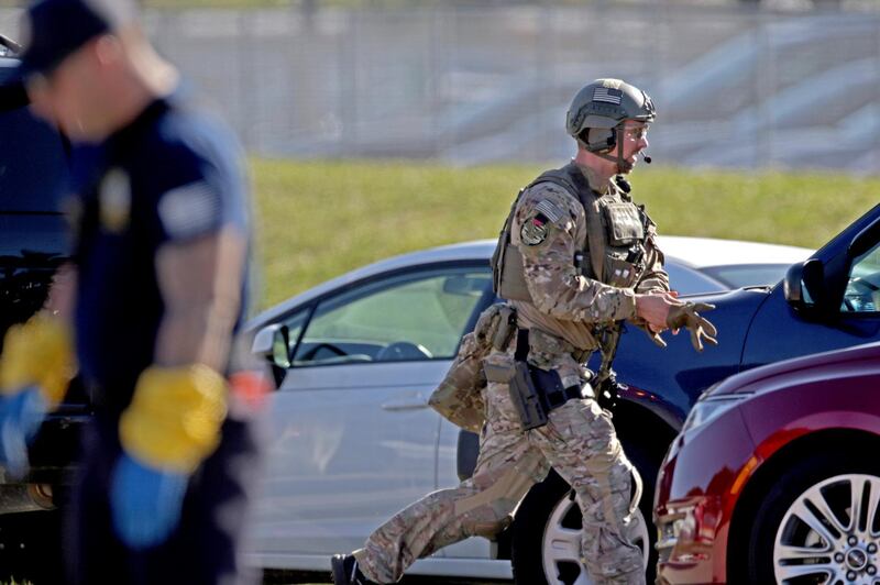 A law enforcement officer rushes toward Marjory Stoneman Douglas High School following a shooting at the school in Parkland, Fla., on Wednesday, Feb. 14, 2018. (John McCall/South Florida Sun-Sentinel via AP)