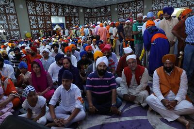 Surender  Kandhari (seated extreme right) near Navdeep Suri, Indian ambassador to the UAE, with hundreds of worshippers inside the main prayer hall of the gurdwara in Dubai.      