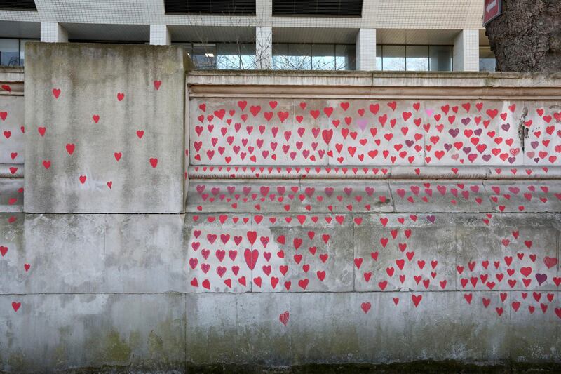 Bereaved family members and volunteers began work on Monday , using paint pens for the hearts and cleaning existing marks off the wall. AP Photo