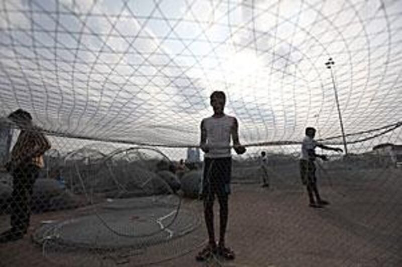 Fishermen at the Mina Port in Abu Dhabi tend to their nets. Some members of the Federal National Council have complained about the preponderance of Asians in the industry.