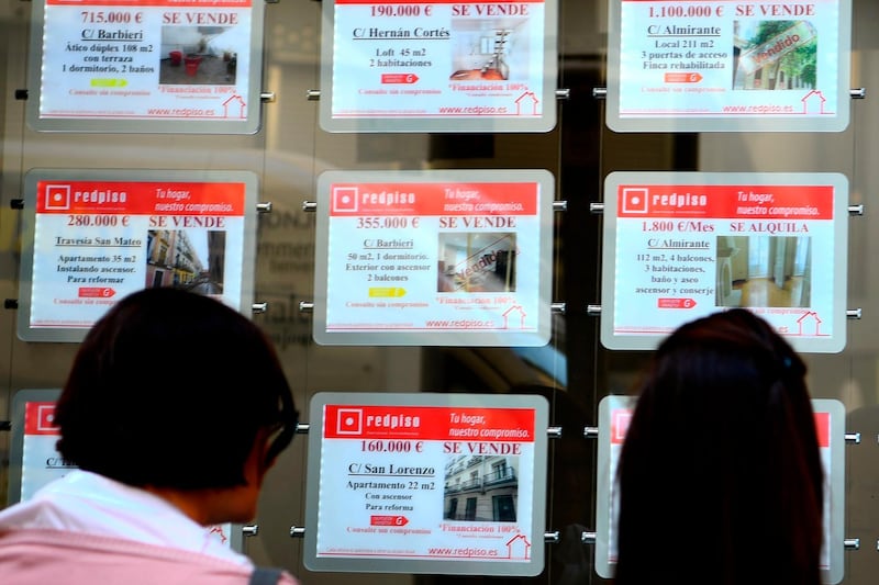 People look at adds displayed on a real state agency in Madrid on September 25, 2018. Capsule flats, price rises forcing tenants out: rents in Spain are soaring post-crisis, fuelling concerns of a new "bubble" in a country still traumatised by the collapse of its housing sector. / AFP / GABRIEL BOUYS                    
