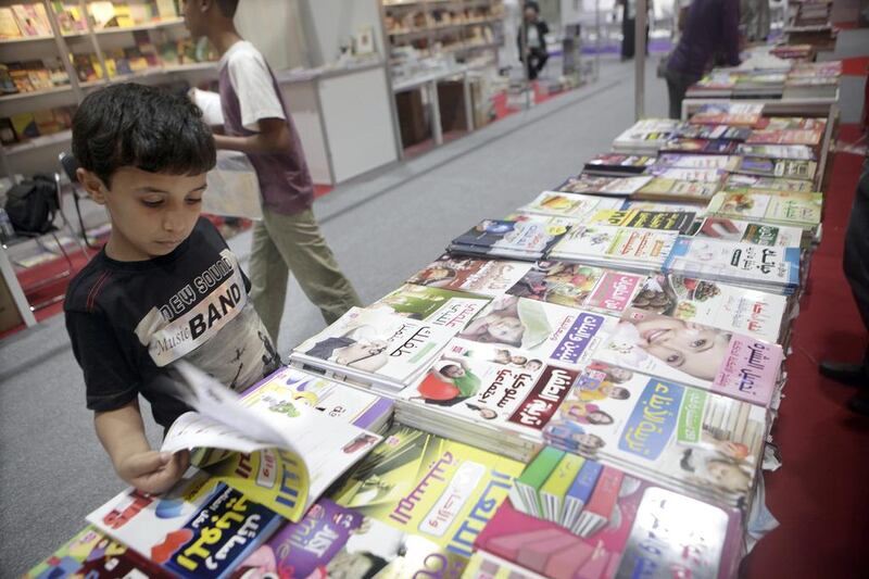 Suhail Omar, 12, looks through books at the Abu Dhabi Book Fair 2013 (Sammy Dallal / The National)