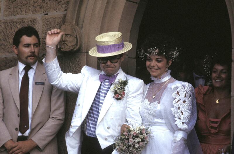 Elton John, wearing a white morning suit and a straw boater hat, with Renate Blauel on their wedding day at St Mark's Church in Sydney, Australia on February 14, 1984. Getty Images