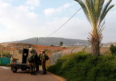 This picture taken on December 4, 2018 near the northern Israeli town of Metula, shows Israeli soldiers standing outside a military vehicle near the border with Lebanon. Israel's army said on December 4 it had detected Hezbollah "attack tunnels" infiltrating its territory from Lebanon and had launched an operation called "Northern Shield" to destroy them, a move likely to raise tensions with the Iran-backed group. / AFP / JALAA MAREY
