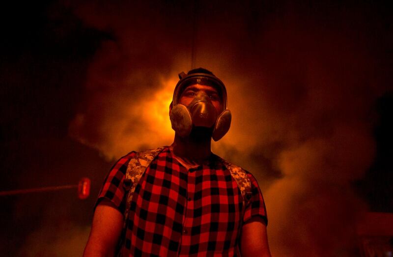 An Iraqi anti-government protester is pictured at a roadblock with burning tyres in the southern Iraqi city of Basra. AFP