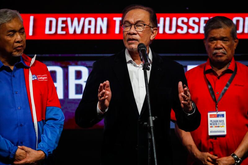 Malaysian Prime Minister Anwar Ibrahim, centre, speaks as Deputy Prime Minister Zahid Hamidi, left, looks on after the state election results in Kuala Lumpur. EPA