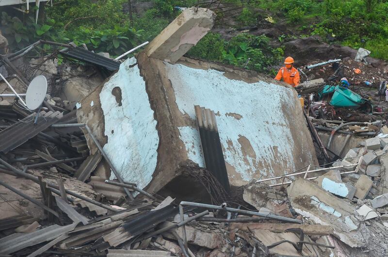 A rescue worker searches for people in the rubble of a five-storey apartment building after it collapsed in Mahad, about 170 kilometres from India's financial capital of Mumbai.  AFP