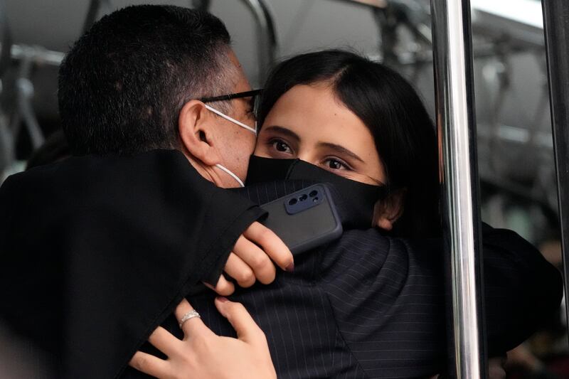 Afghan musician Marzia Anwari, right, hugs Ahmad Naser Sarmast, founder and director of the Afghanistan National Institute of Music, at Lisbon military airport. AP Photo