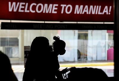 Tourists wear protective masks as a precaution against the spread of coronavirus at Manila International Airport. AP Photo