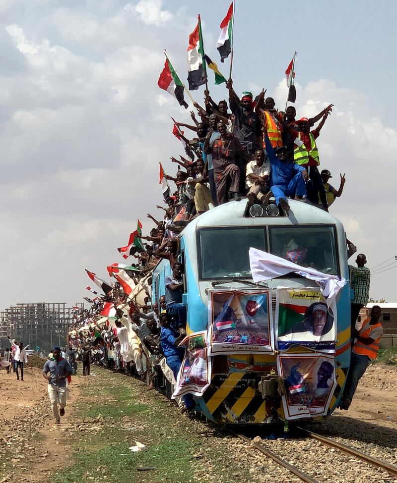 Sudanese civilians from other provinces ride on the train to join in the celebrations of the signing of Sudan's power-sharing deal. Reuters