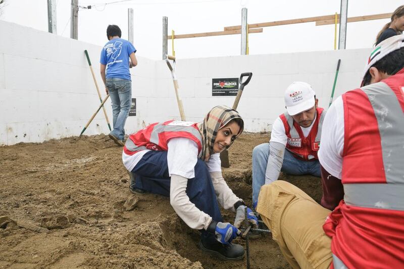 From left, Tuaiba Al Darmaki, Hasan Al Ali of Takatof, and Adel Al Areefi working on the Habitat for Humanity project to rebuild the home of Leslie Morris.