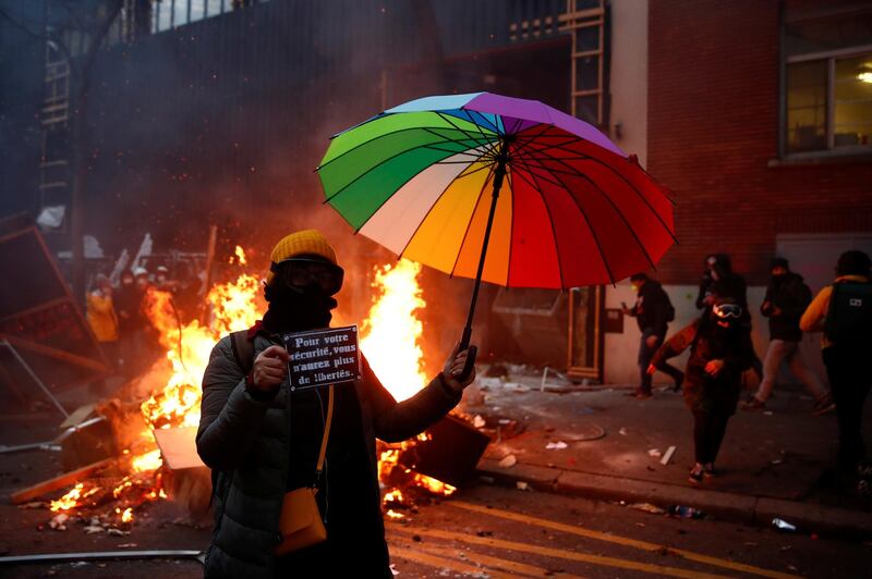 A demonstrator holds an umbrella and a sign reading "For your safety you will have no more freedoms" during a protest against the "Global Security Bill'', that right groups say would make it a crime to circulate an image of a police officer's face and would infringe journalists' freedom in the country, in Paris, France. Reuters